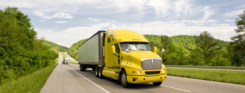 yellow semi truck travels on interstate in springtime SYv1z06No