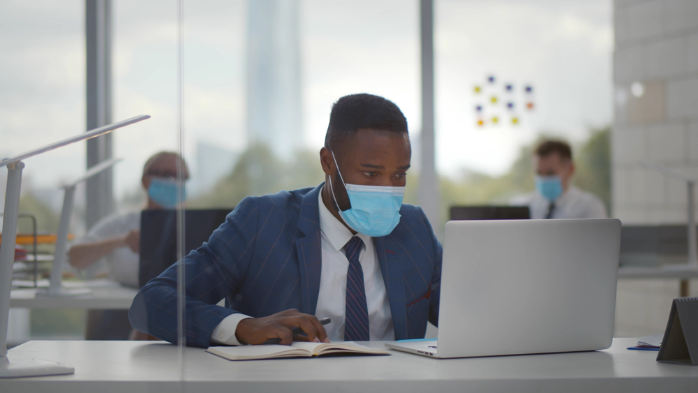 African American man in suit with face mask on