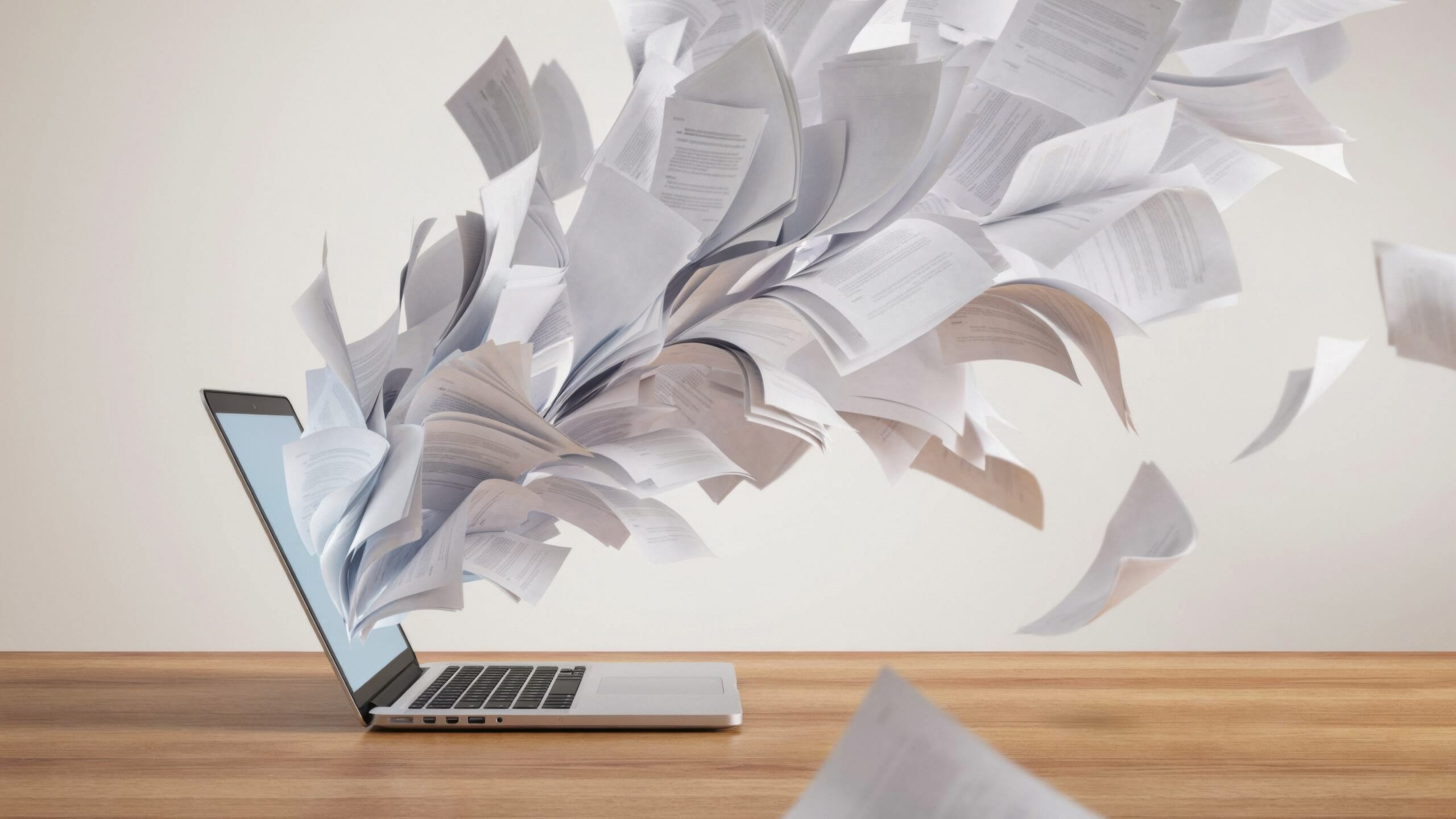 laptop computer with many documents flying out of the screen